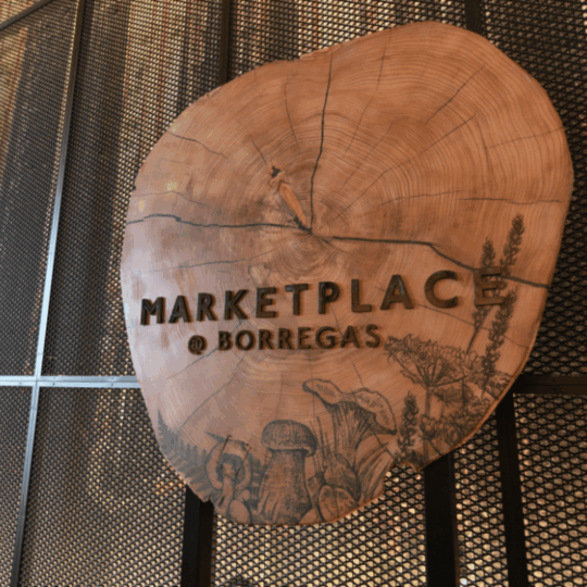 At Google's vibrant campus, meticulously crafted by BLR Visual, our Marketplace Services entrance sign stands as a captivating testament to the fusion of nature and technology. Fashioned from a refined redwood tree trunk, its smooth finish allows for the direct printing of an intricately detailed image, showcasing the remarkable mass timber theme in all its glory.