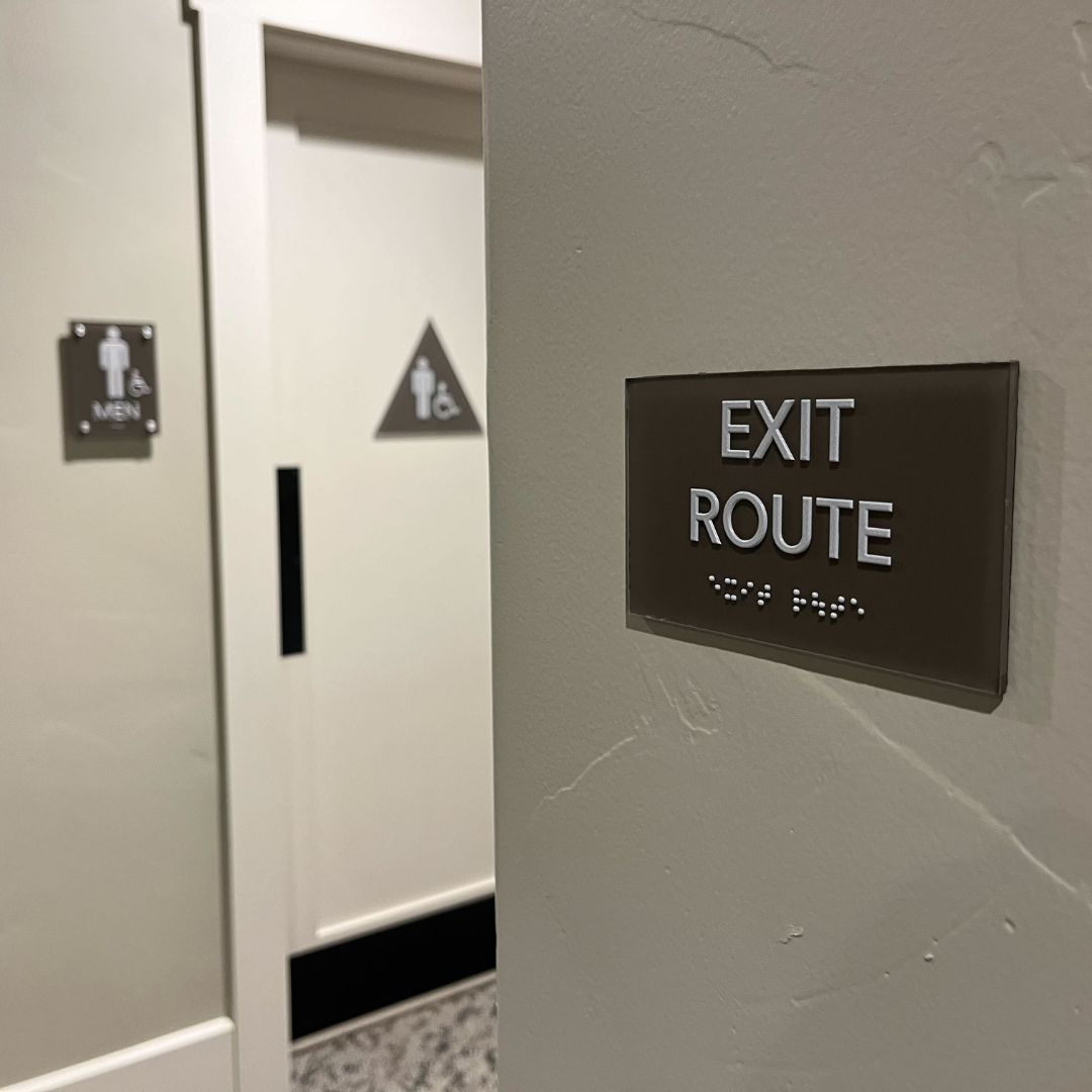 Interior directional signage system designed and installed at San Juan Oaks Golf Club, featuring clear room labels and custom branded wayfinding elements.